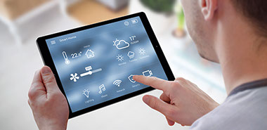 Mann steuert sein Smart-Home komfortabel über ein Tablet